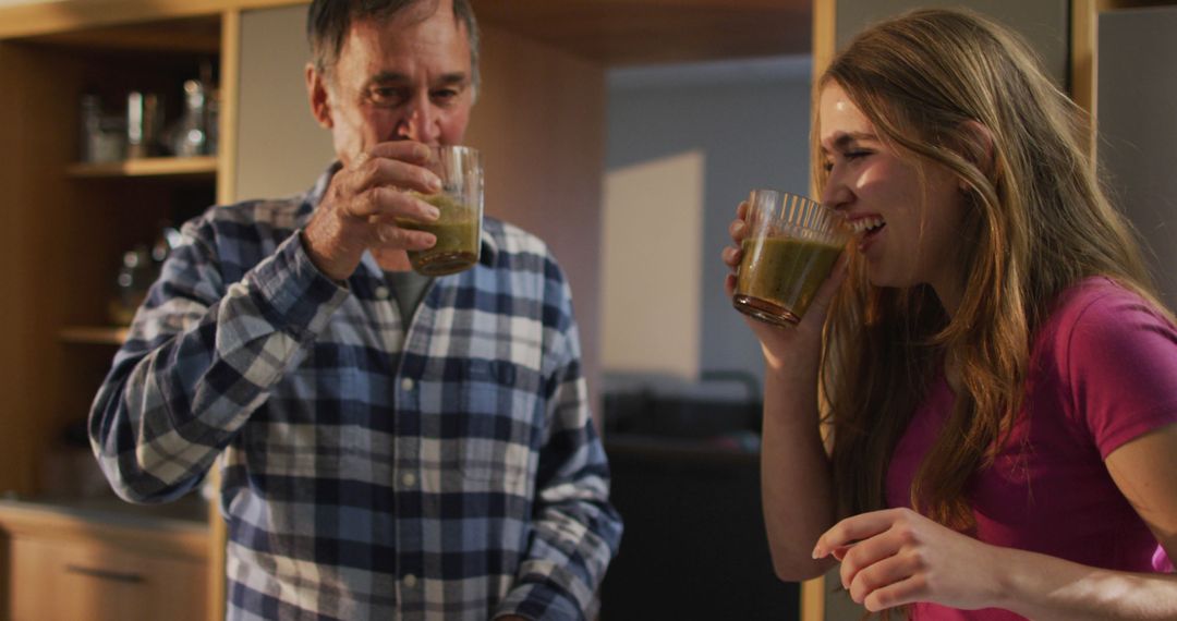 Father and Daughter Enjoying Green Smoothies Together at Home - Free Images, Stock Photos and Pictures on Pikwizard.com