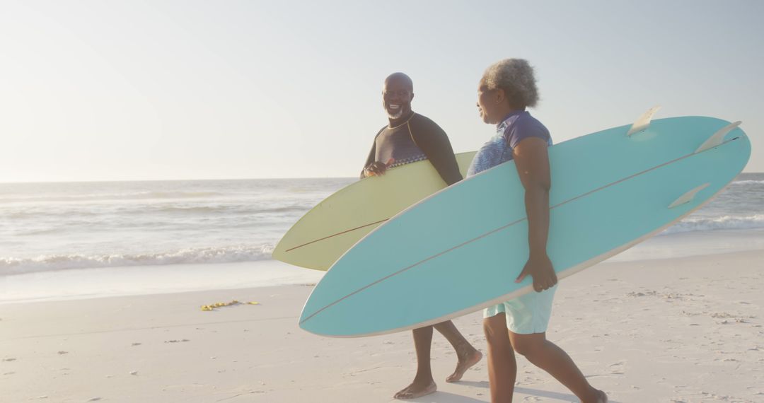 Senior Couple Surfing at Beach Sunset - Free Images, Stock Photos and Pictures on Pikwizard.com