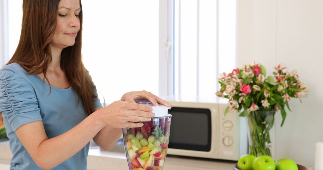 Woman blending mixed fruit in modern kitchen - Free Images, Stock Photos and Pictures on Pikwizard.com