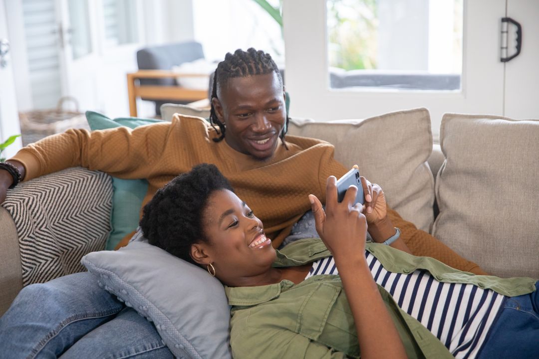 Peaceful Couple Enjoying Relaxing Time on Sofa with Smartphone