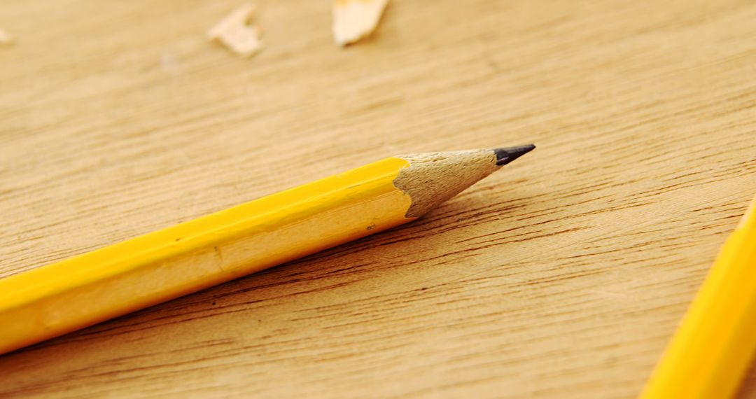 Close-up of freshly sharpened yellow pencil on wooden surface - Free Images, Stock Photos and Pictures on Pikwizard.com