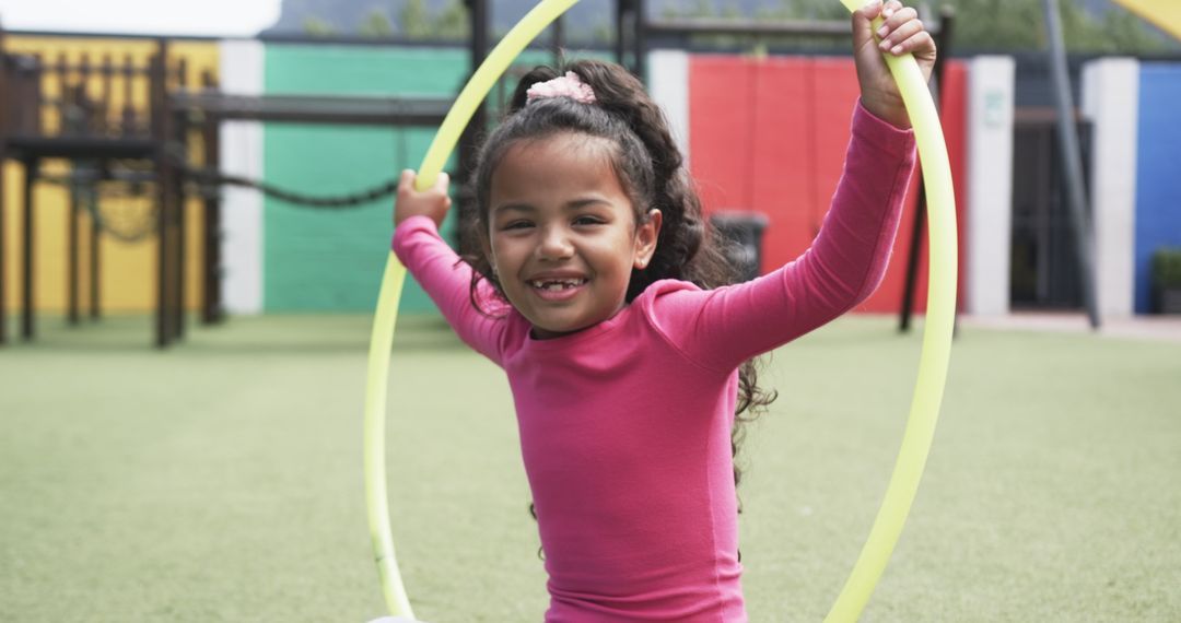 Joyful African American Girl Playing with Hula Hoop in Playground