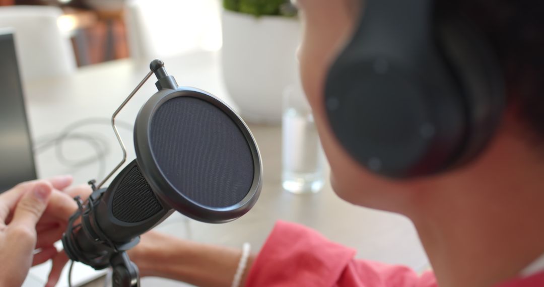 Podcaster Speaking into Professional Microphone with Headphones On