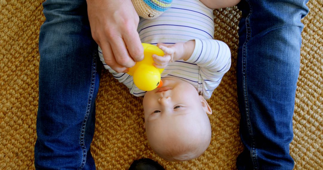 Baby playing with yellow rubber duck on woven carpet - Free Images, Stock Photos and Pictures on Pikwizard.com