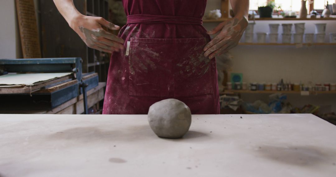 Person Wearing Dirty Apron Preparing to Sculpt Clay in Studio - Free Images, Stock Photos and Pictures on Pikwizard.com