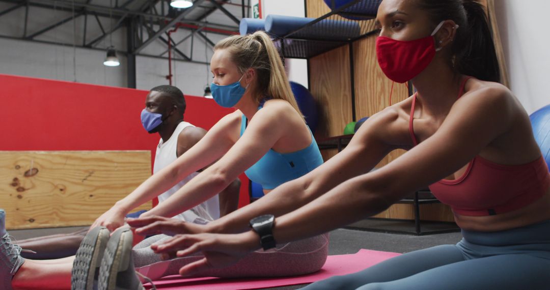 People Stretching on Yoga Mats Wearing Face Masks in Gym - Free Images, Stock Photos and Pictures on Pikwizard.com