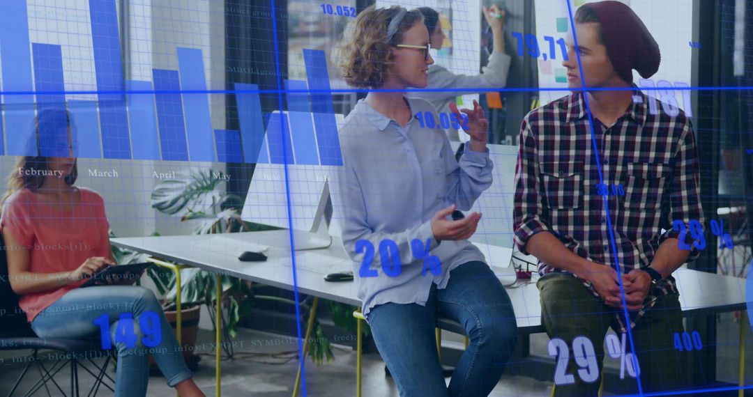 Young Professionals Discussing Data and Ideas in Modern Office