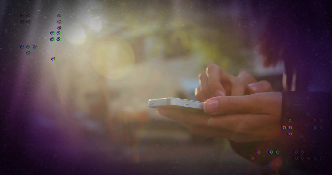 Person Using Smartphone on Sunlit Street