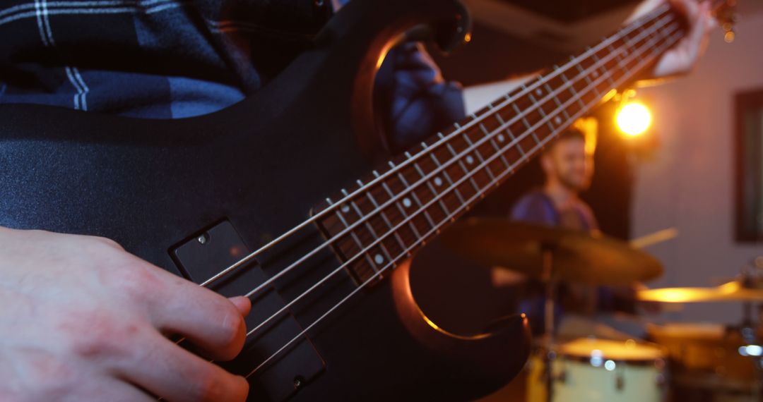 Close-up of Musician Playing Black Electric Bass Guitar in Studio - Free Images, Stock Photos and Pictures on Pikwizard.com