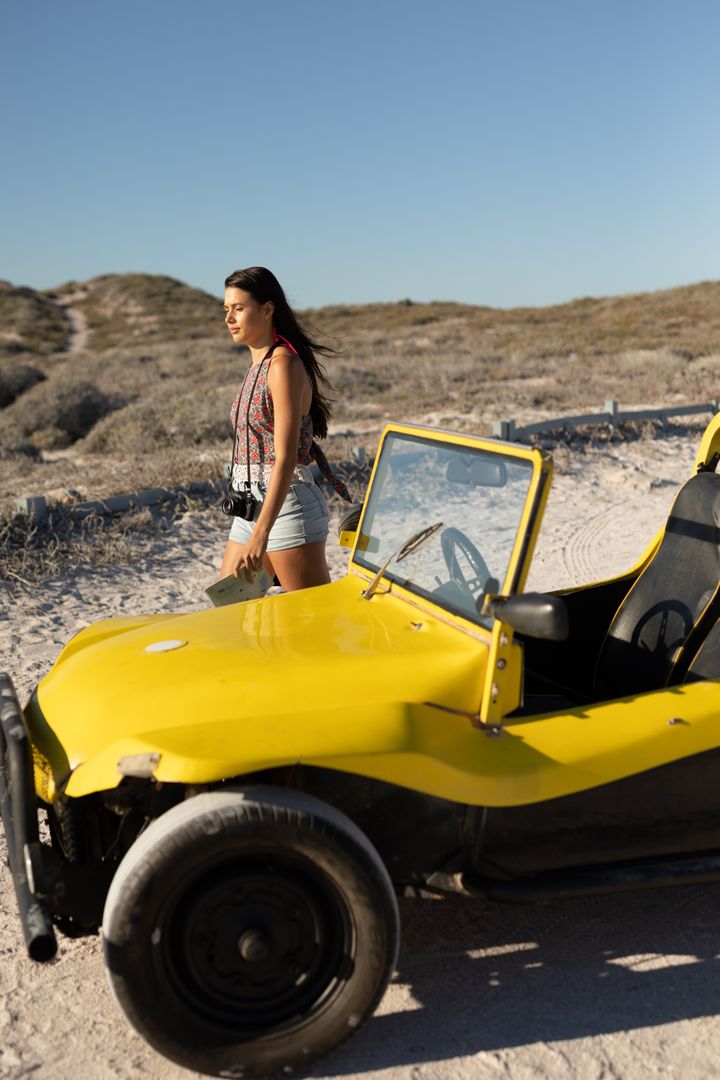 Woman Walking Away from Beach Buggy on Sunny Beach - Free Images, Stock Photos and Pictures on Pikwizard.com