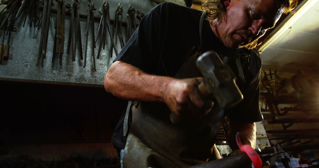 Skilled Blacksmith Forging Iron Rod in Workshop