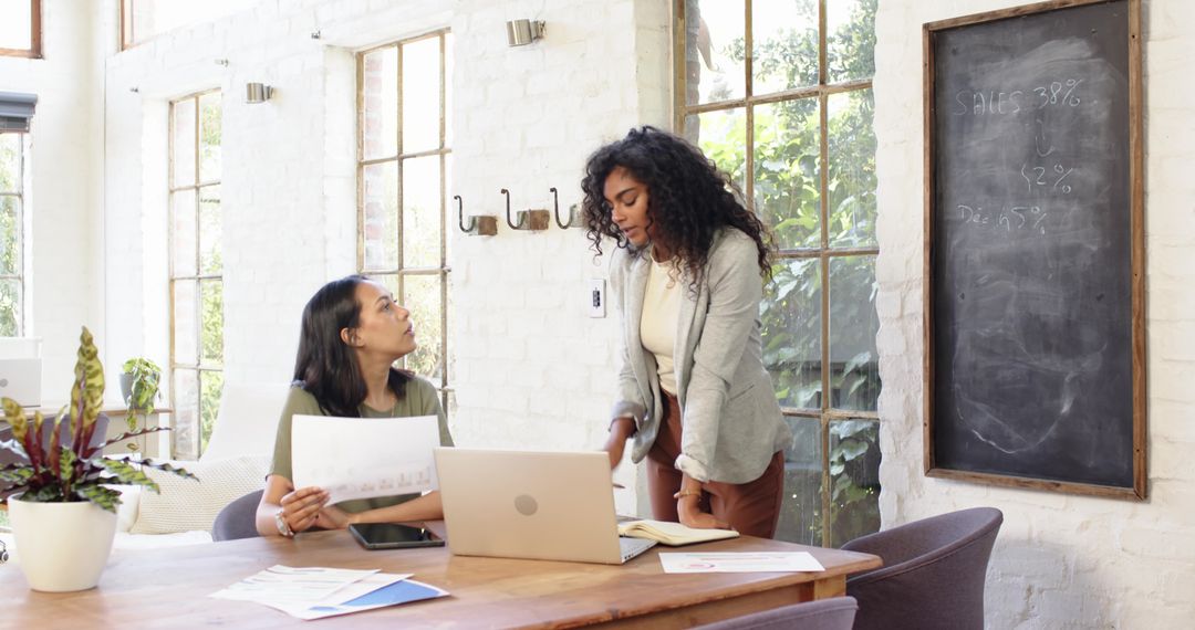 Professional Teamwork in Modern Meeting Room with Laptop and Chalkboard