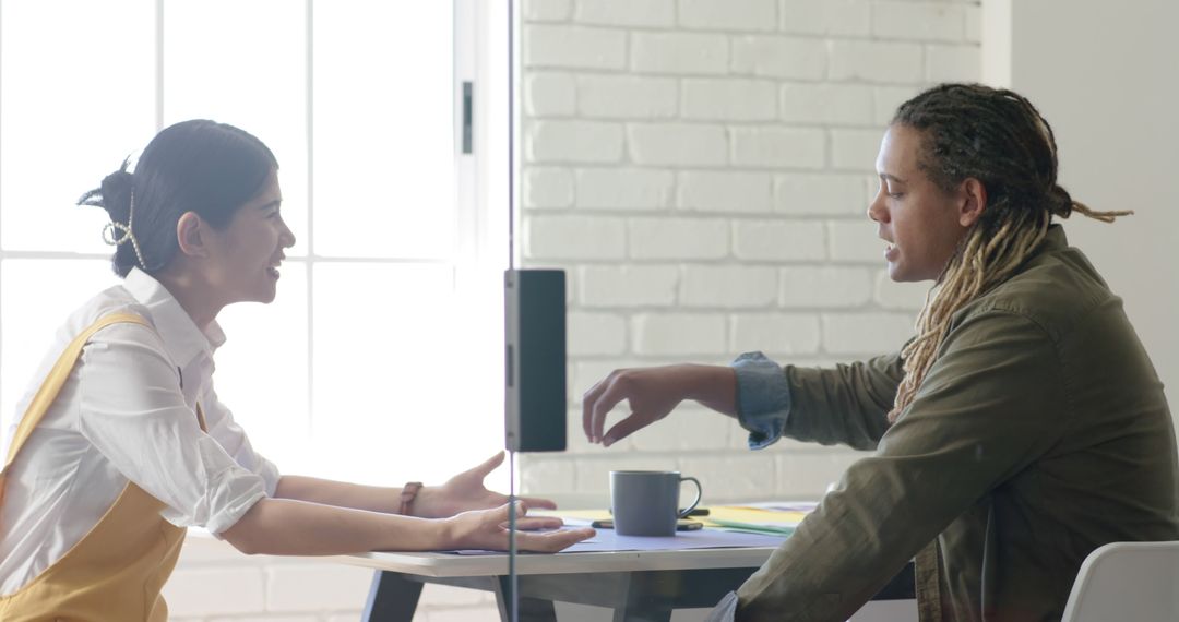 Diverse Colleagues Engaging in Office Discussion at Desk