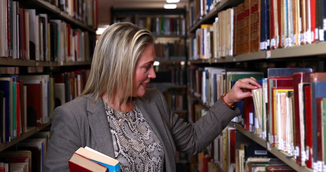 A middle-aged Caucasian woman browses through books in a library aisle, with copy space - Free Images, Stock Photos and Pictures on Pikwizard.com