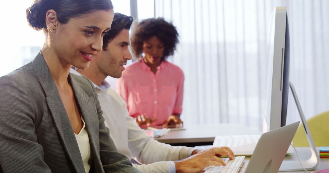 Confident Business Team Collaborating on Laptops in Modern Office