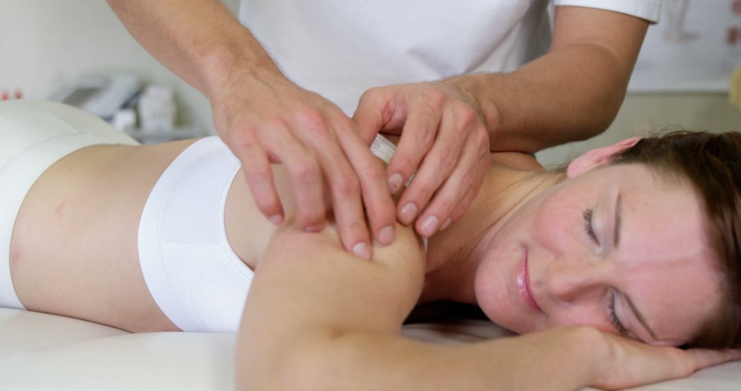 Woman Receiving Professional Shoulder Massage in Wellness Center - Free Images, Stock Photos and Pictures on Pikwizard.com