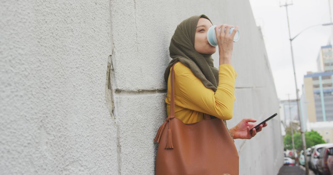 Young Muslim Woman Drinking Coffee and Using Smartphone - Free Images, Stock Photos and Pictures on Pikwizard.com