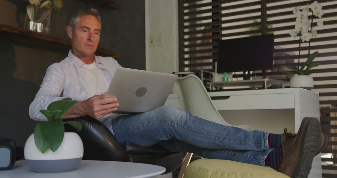 Mature man working on laptop in modern home office - Free Images, Stock Photos and Pictures on Pikwizard.com