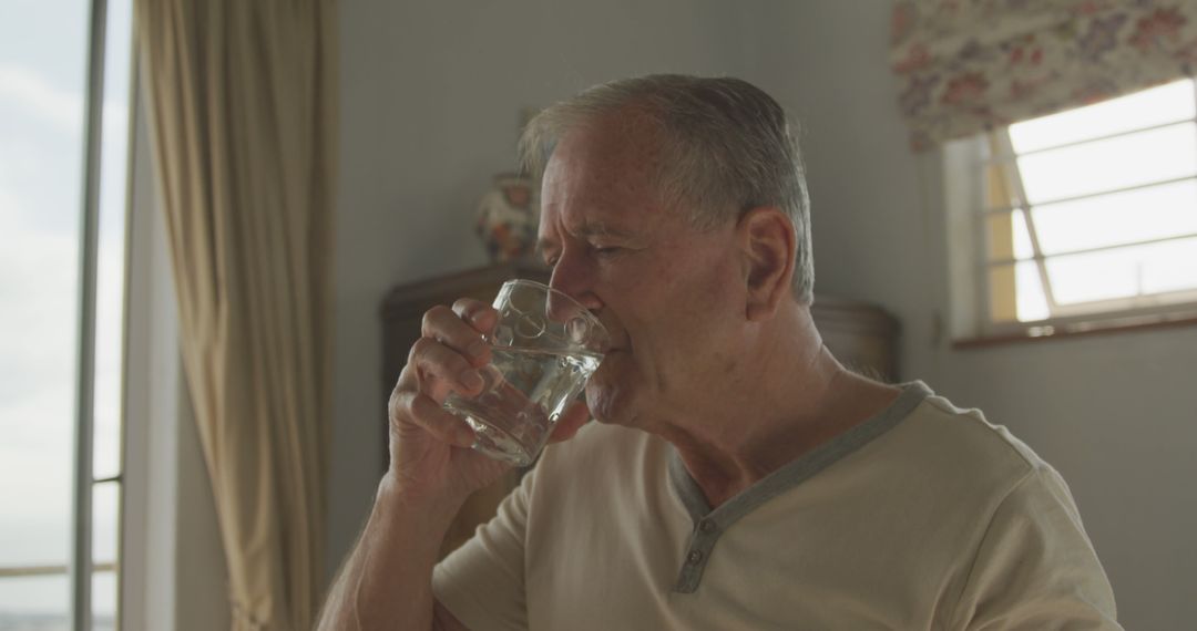 Senior man drinking water at home, staying hydrated indoors - Free Images, Stock Photos and Pictures on Pikwizard.com