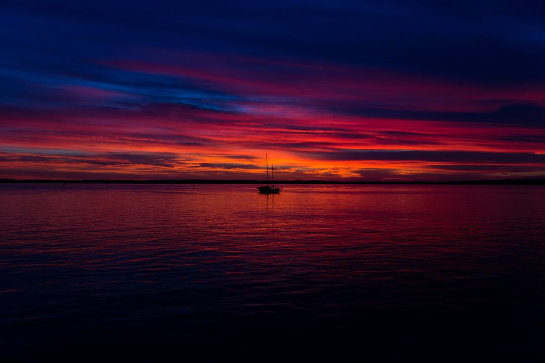 Tranquil Sailboat on Vibrant Ocean Sunset - Free Images, Stock Photos and Pictures on Pikwizard.com