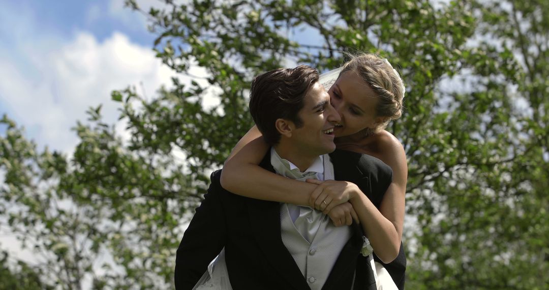 Joyful Bride Piggybacking Groom Outdoors - Free Images, Stock Photos and Pictures on Pikwizard.com