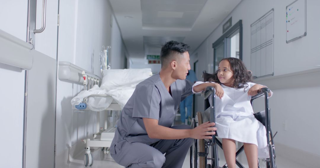 Doctor Comforting Young Girl in Wheelchair in Hospital Corridor - Free Images, Stock Photos and Pictures on Pikwizard.com