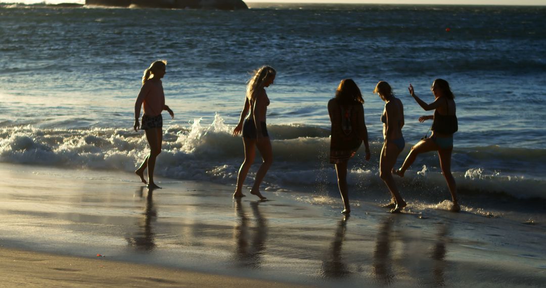 Caucasian women enjoy a playful moment on the beach at sunset - Free Images, Stock Photos and Pictures on Pikwizard.com