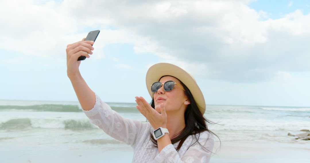 Woman Blowing Kiss While Taking Selfie at Beach - Free Images, Stock Photos and Pictures on Pikwizard.com