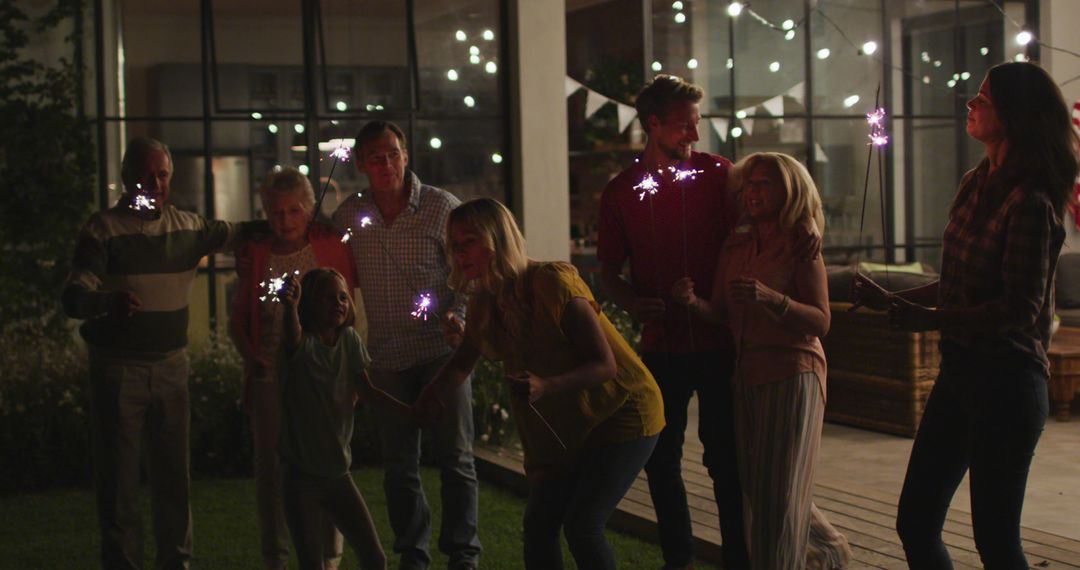 Family Celebrating Outside at Night with Sparklers - Free Images, Stock Photos and Pictures on Pikwizard.com