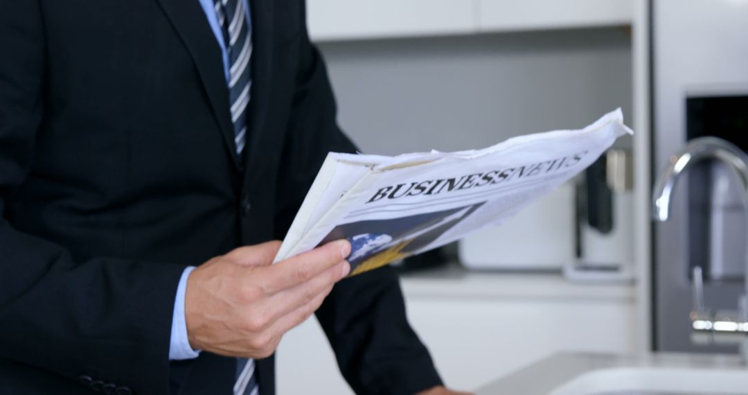 Businessman Reading Newspaper in Modern Office Kitchen - Free Images, Stock Photos and Pictures on Pikwizard.com