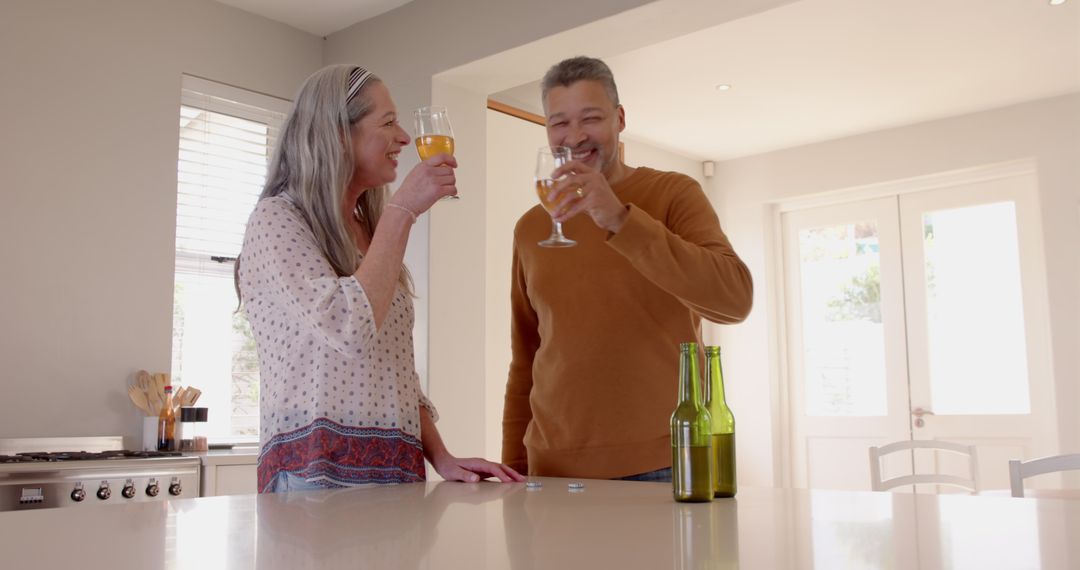 Mature Couple Enjoying Wine and Laughter in Modern Kitchen
