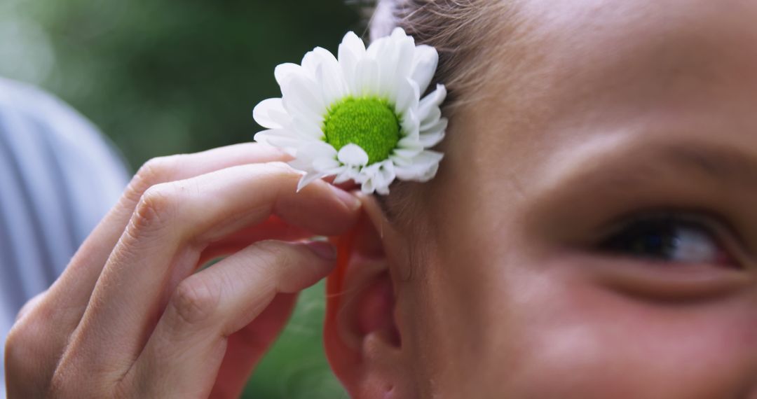 Child Holding Flower Next to Ear in Nature - Free Images, Stock Photos and Pictures on Pikwizard.com