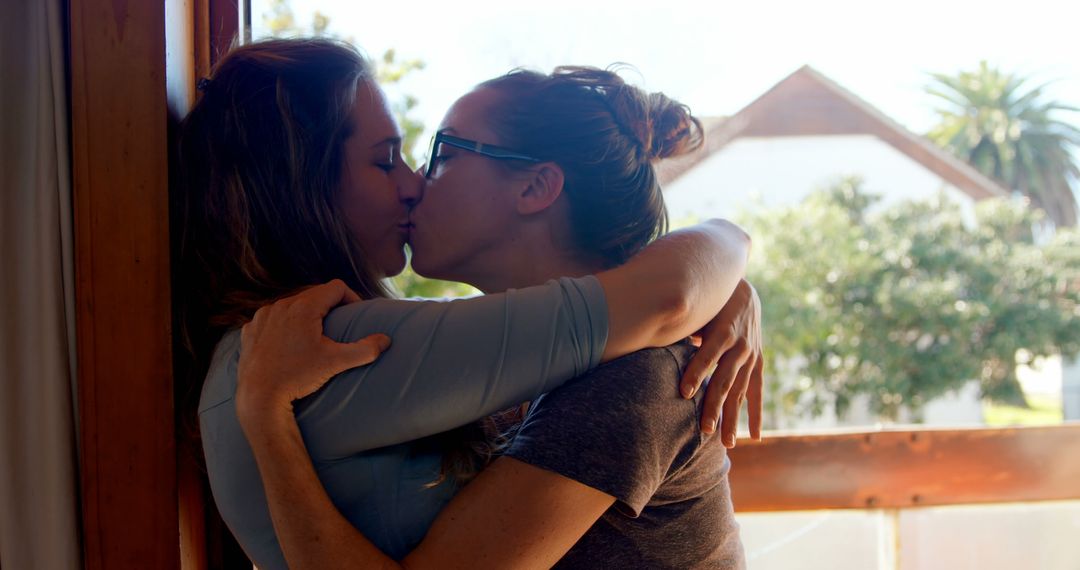 Romantic Moment Between Two Women Sharing a Kiss Near Window - Free Images, Stock Photos and Pictures on Pikwizard.com