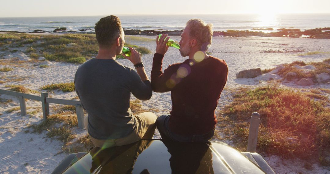 Two Men Drinking Beer at Beach During Sunset - Free Images, Stock Photos and Pictures on Pikwizard.com