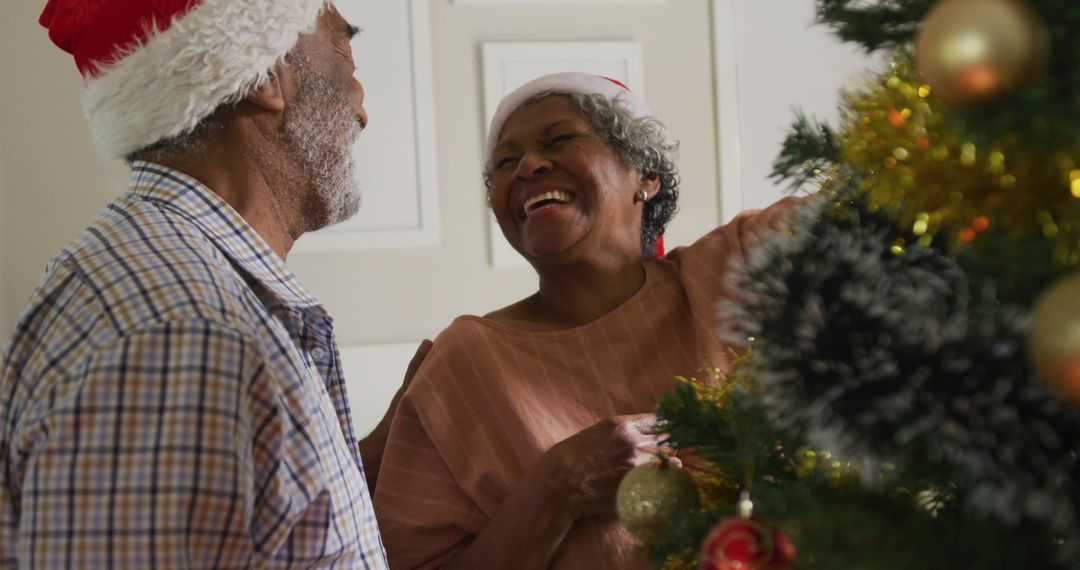 Image of happy african american senior couple decorating christmas tree together - Free Images, Stock Photos and Pictures on Pikwizard.com