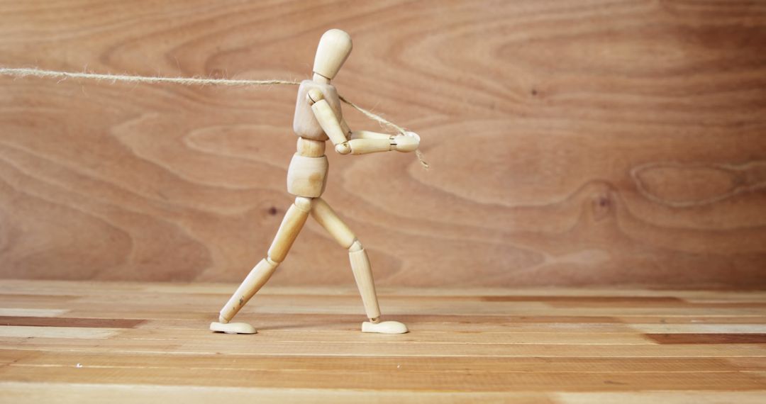 Wooden Mannequin Pulling Rope on Wooden Background - Free Images, Stock Photos and Pictures on Pikwizard.com