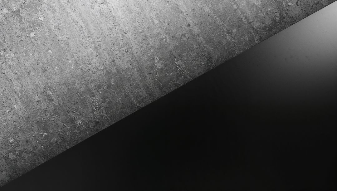 Highlighting Textured Concrete Contrasting Smooth Black Panel Diagonal Minimalist Composition