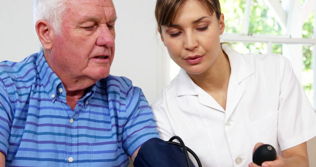 Nurse checking elderly man’s blood pressure in home - Free Images, Stock Photos and Pictures on Pikwizard.com