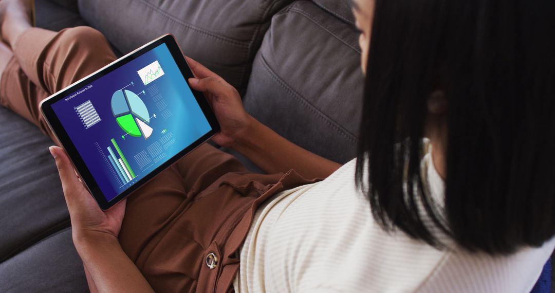 Woman Analyzing Data on Tablet While Relaxing at Home