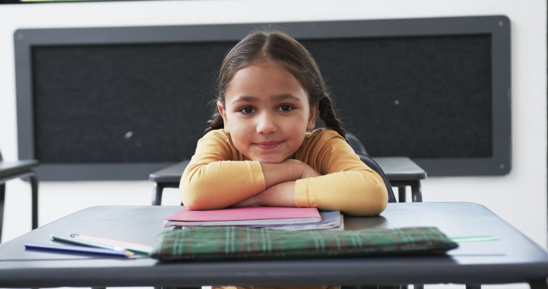 Smiling Schoolgirl in Classroom with Notebooks