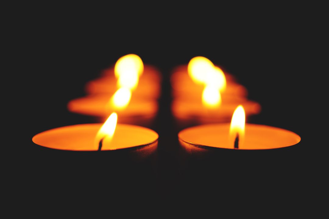 Rows of Burning Tea Light Candles in Dark Environment