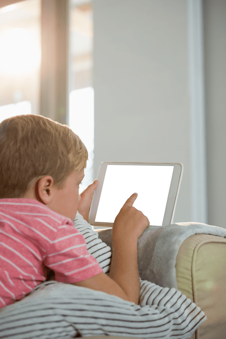 Child Engaged with Transparent Tablet on Cozy Sofa