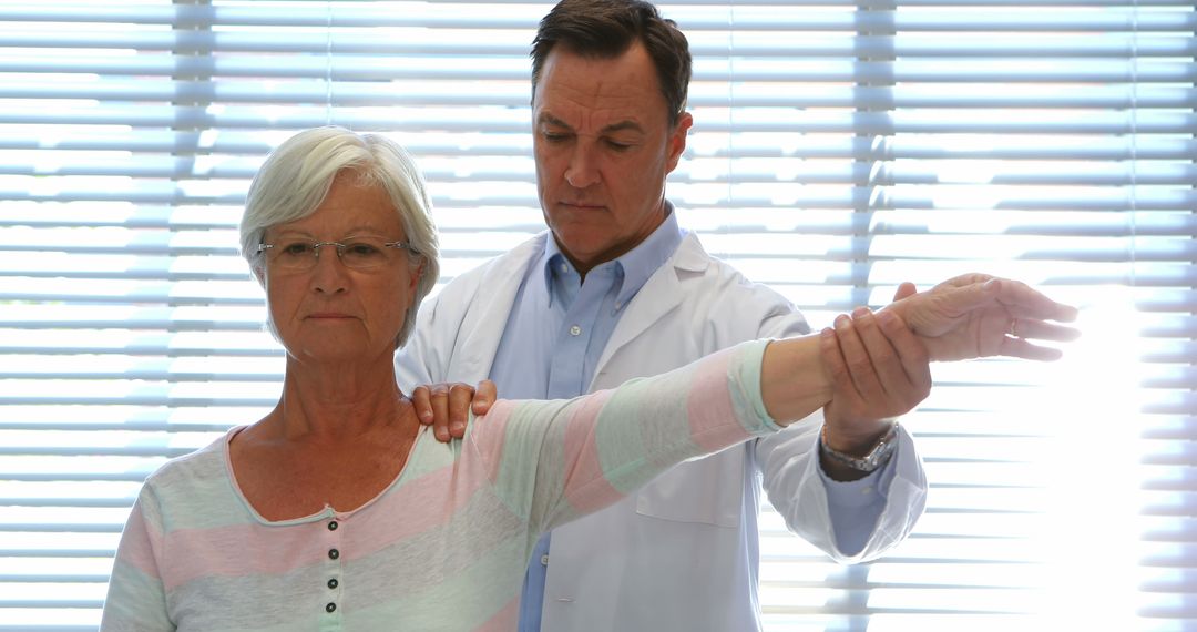 Doctor Examining Elderly Patient's Arm Mobility - Free Images, Stock Photos and Pictures on Pikwizard.com