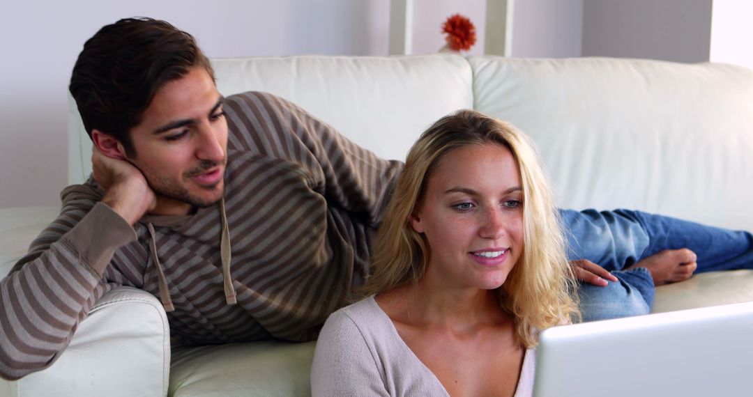 Happy Couple Relaxing on Couch Using Laptop