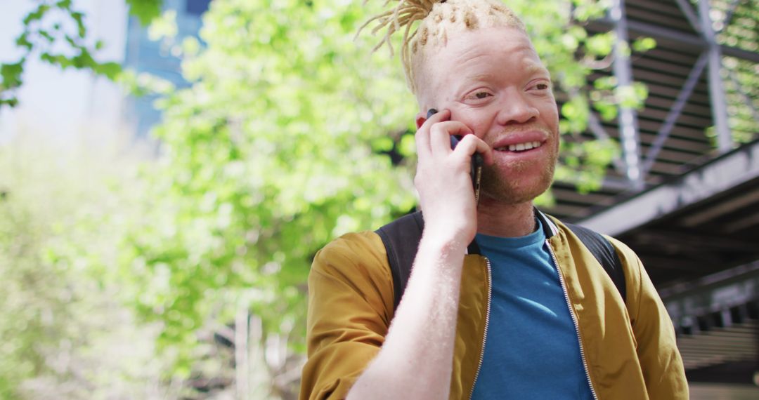 Albino Man Talking on Smartphone in Outdoor Urban Setting - Free Images, Stock Photos and Pictures on Pikwizard.com