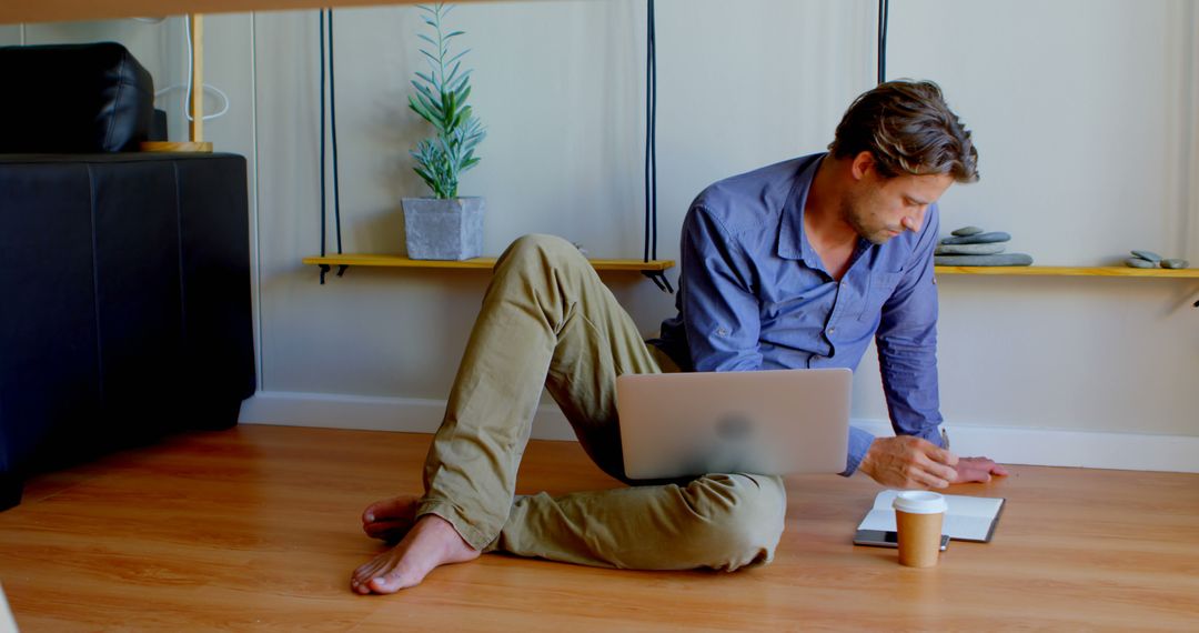 Remote Worker Sitting on Floor Using Laptop and Mobile Phone - Free Images, Stock Photos and Pictures on Pikwizard.com