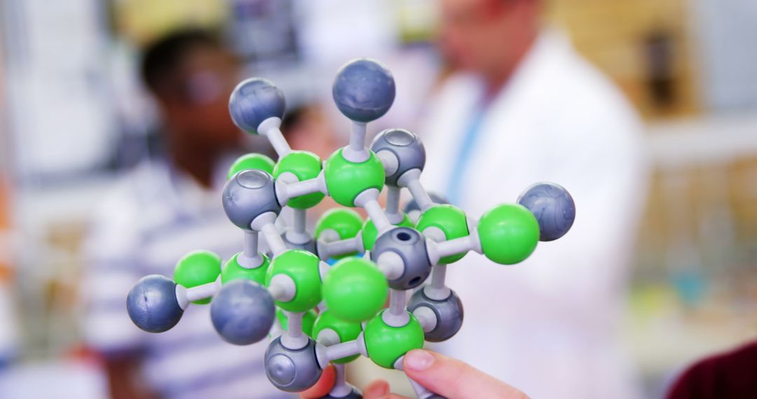 Scientist Holding Molecular Model in Classroom Laboratory - Free Images, Stock Photos and Pictures on Pikwizard.com