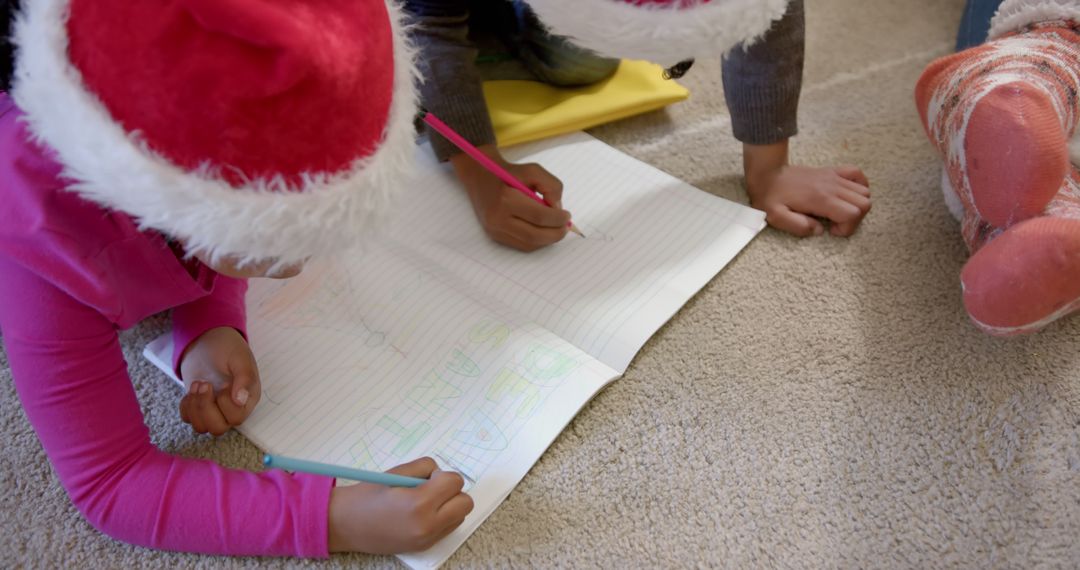 Children Writing Letters in Christmas Hats on Carpet - Free Images, Stock Photos and Pictures on Pikwizard.com