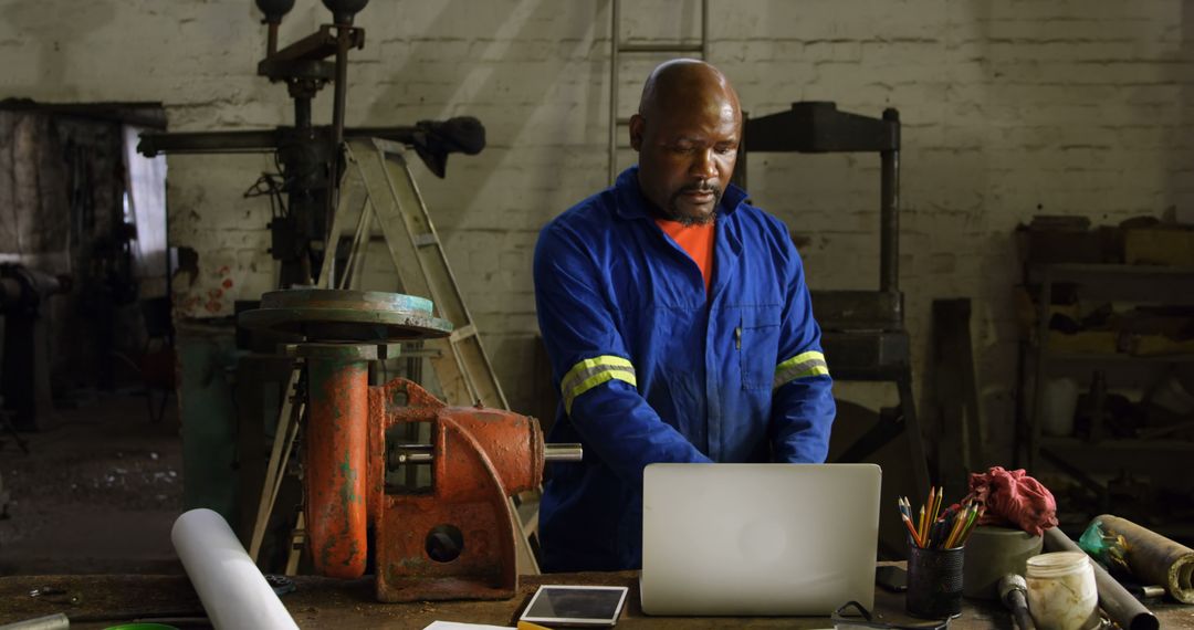 Industrial Worker in Workshop Using Laptop for Project Management - Free Images, Stock Photos and Pictures on Pikwizard.com