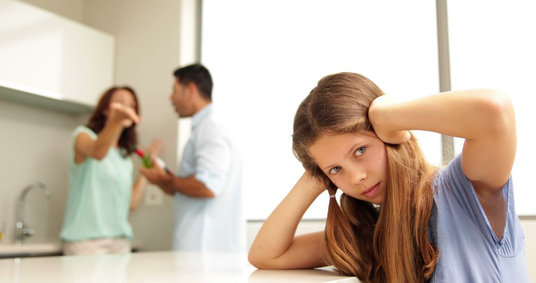 Distraught Child Covering Ears While Parents Arguing in Kitchen - Free Images, Stock Photos and Pictures on Pikwizard.com